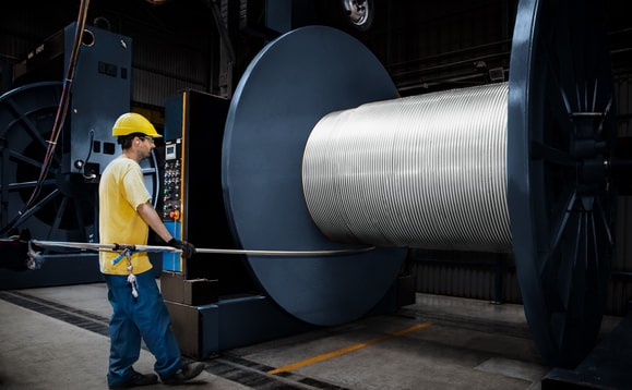 a person wearing a hard hat and holding a cable